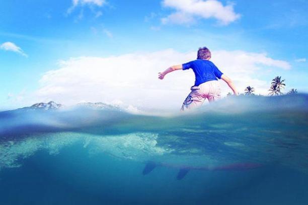 a man flying through the air while riding a wave in the ocean