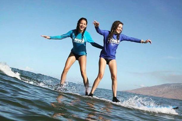 a young girl riding a wave on a surfboard in the water