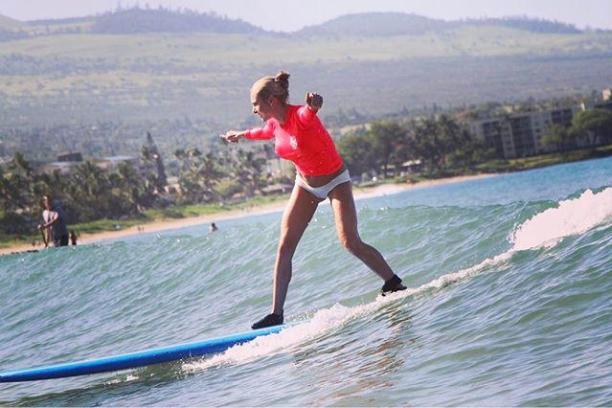 a girl riding a wave on a surfboard in the water