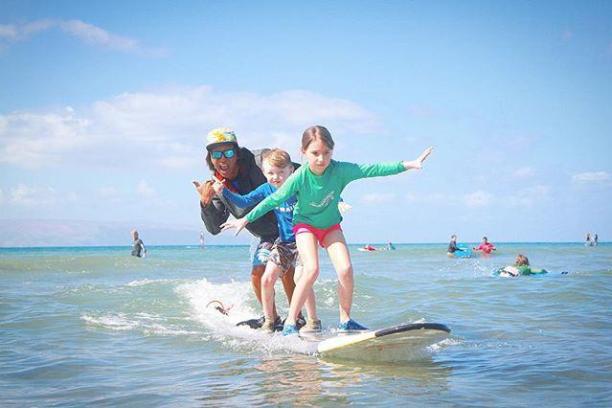 a young girl riding a wave on a surfboard in the water