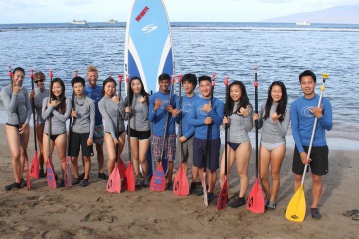 a group of people standing on a beach posing for the camera