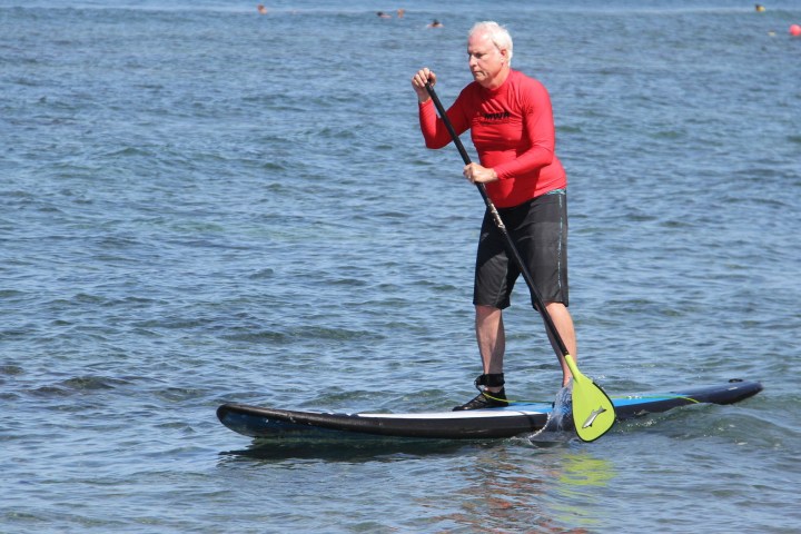 a man riding on the back of a boat in a body of water