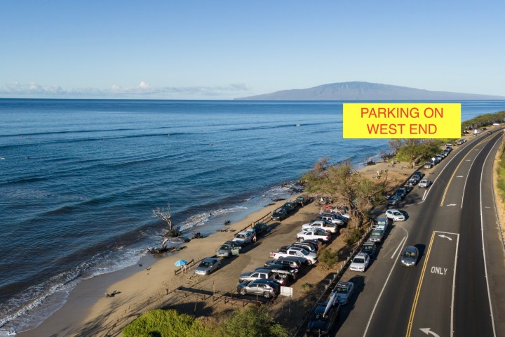 a beach that has a sign on the side of a road