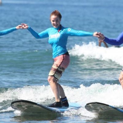 a girl riding a wave on a surfboard in the water